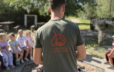 Uczniowie klasy 1d, słuchający zasad gry terenowej w kt&oacute;rej wzięli udział podczas wycieczki do Granicy &bdquo;Domu Pracy Tw&oacute;rczej&rdquo;. 
