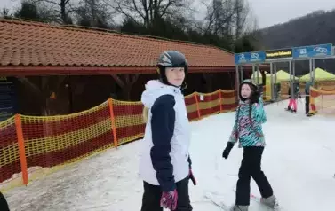 uczniowie stoją przy bramce na wyciąg saneczkowy